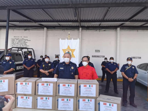 图为墨西哥尤卡坦半岛华人华侨联合会向梅里达市政府捐赠一次性医用口罩20000个，市警察局局长代表市政府接收捐赠。受访者供图。
