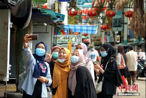 7月12日，因疫情暴发歇业的马来西亚吉隆坡茨厂街获准重新开业，图为马来西亚本地游客在茨厂街自拍。中新社记者 陈悦 摄
